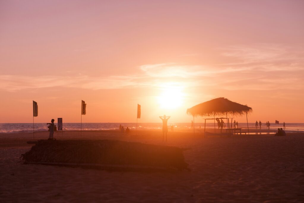 People enjoying the beach under a bright sun with stunning orange skies at Hikkaduwa