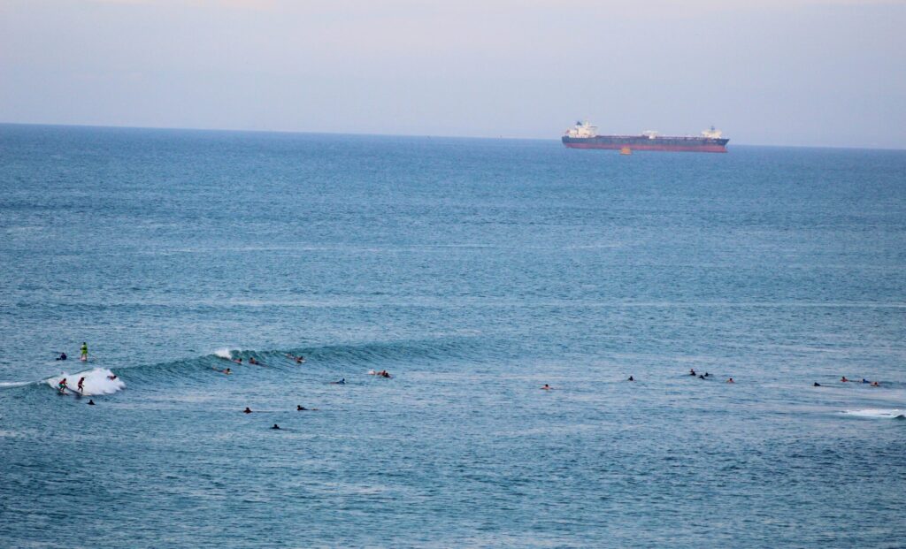 El Barco in Salinas surf, Ecuador, featuring surfers catching waves with a long ship in the background