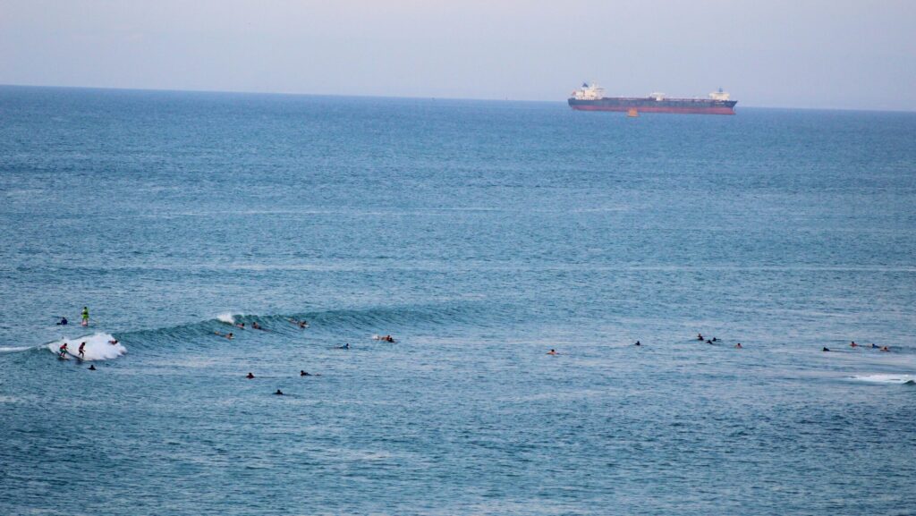 El Barco in Salinas surf, Ecuador, featuring surfers catching waves with a long ship in the background