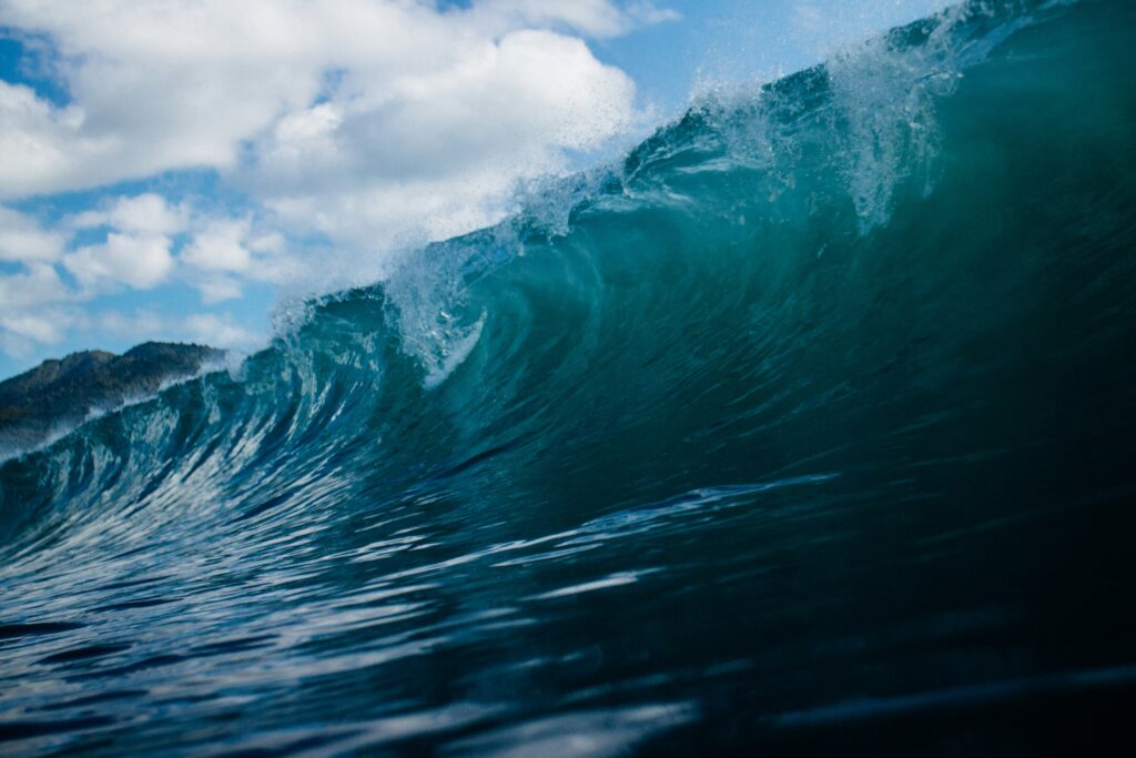 A photo of a rolling blue wave captured from within the water at Puerto Viejo Surf