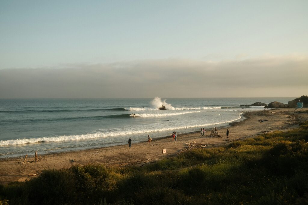 Perfect right hand waves at Malibu in USA surf with people walking on the beach