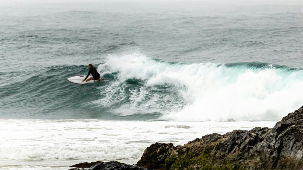 Surfer executing a big turn on a right-hand wave at Snapper Rocks, Coolangatta, with vibrant ocean colors