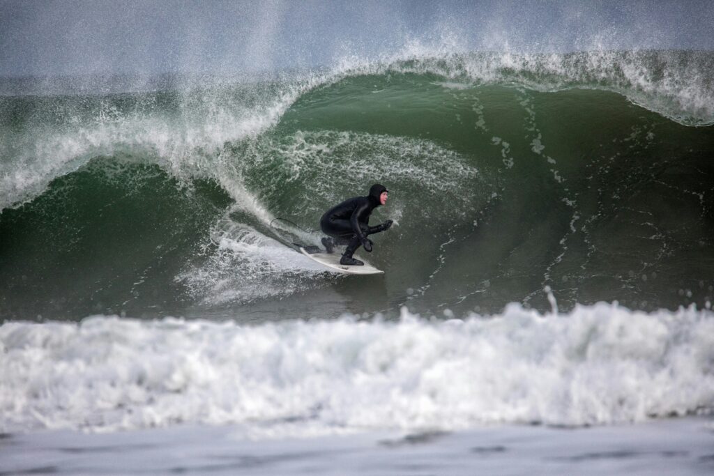 A surfer in a huge left hand barrel at Scarborough Beach - Maine in USA Surf