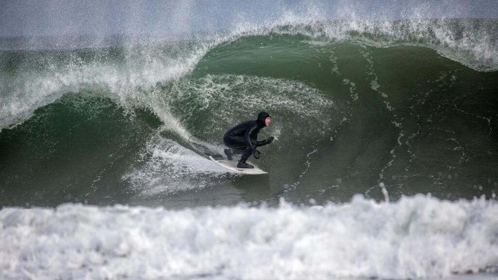 A surfer in a huge left hand barrel at Scarborough Beach - Maine in USA Surf