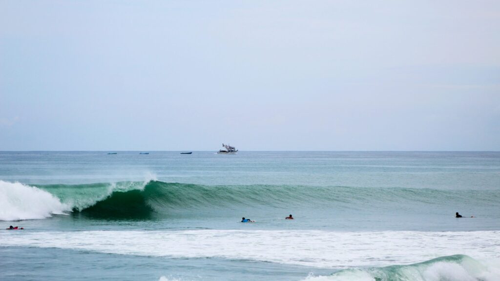 Ecuador Surf Guide 2025 | Best Surf Towns With Easy Access A long left-hand surf break at El Barco in Salinas surf, Ecuador surf, featuring vibrant blue water and clear blue skies
