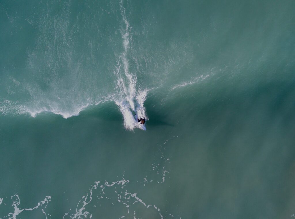 A bird's-eye view of a surfer just taking off on a left-hand wave, captured mid-action in Mompiche surf, ecuador