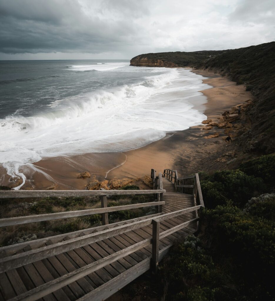 Powerful shore break at Bells Beach, Torquay, with dark clouds looming overhead