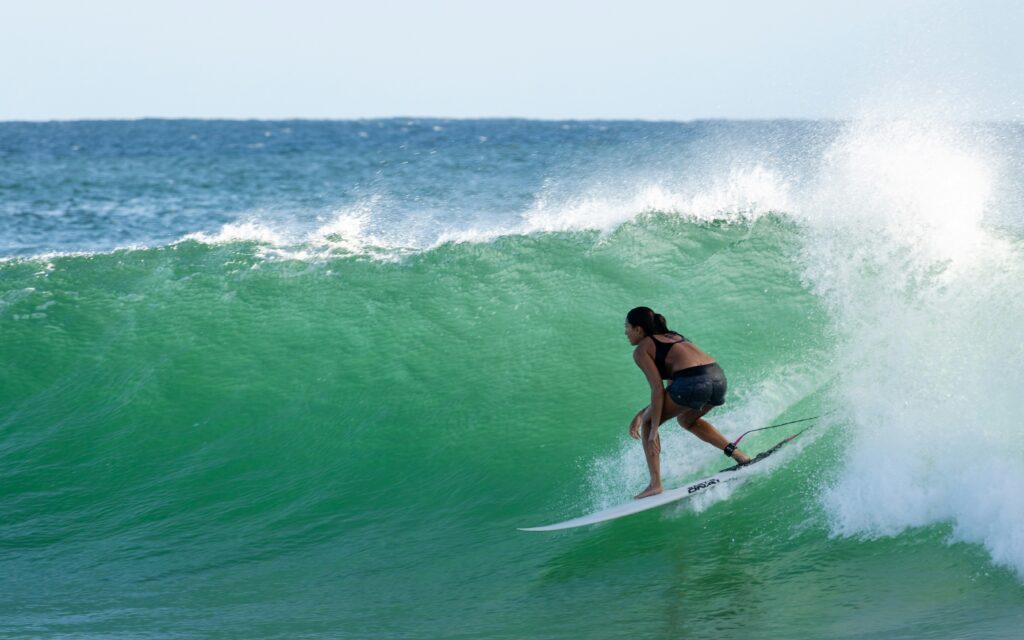 Surfer riding a right-hand wave, gazing down the line at Snapper Rocks, Coolangatta, with clear skies