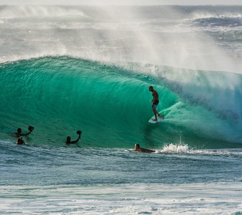 Mick Fanning in a barrel at Duranbah in Coolangatta Surf, with surf photographers in the water capturing the thrilling moment