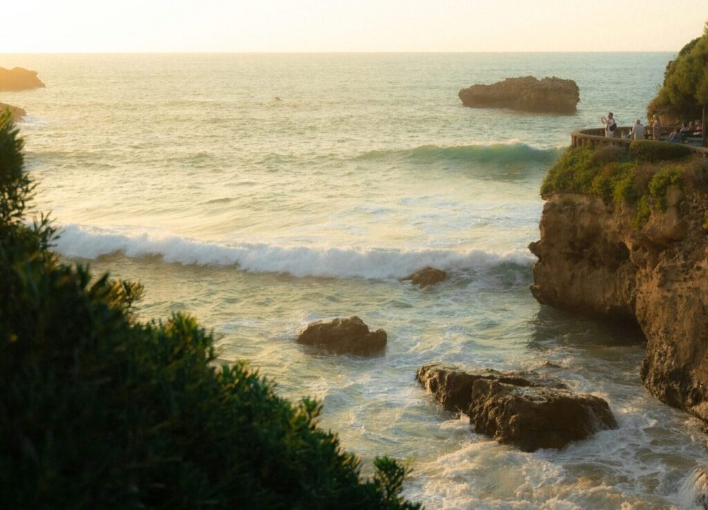 The cliff face of Biarritz, France, overlooking the ocean, with rugged rocks below and waves crashing against the shore