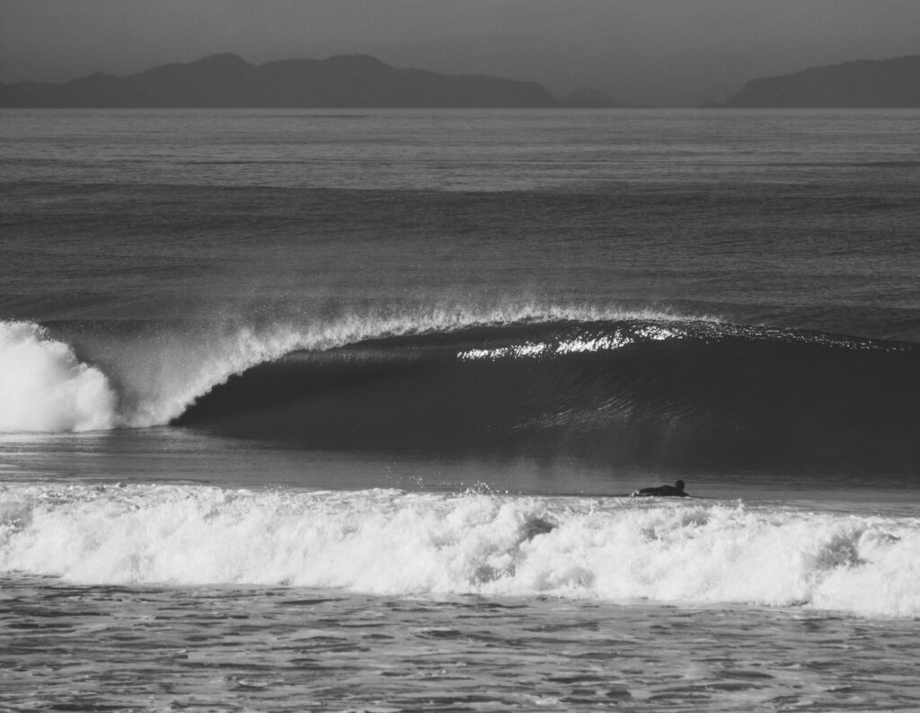 A black and white photo of a perfectly barreling wave in Anglet surf, France