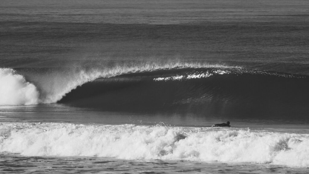 A black and white photo of a perfectly barreling wave in Anglet surf, France