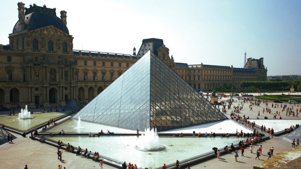 The Louvre Museum in Paris, France, featuring the iconic glass pyramid and its striking angles, beautifully framed against the historic architecture
