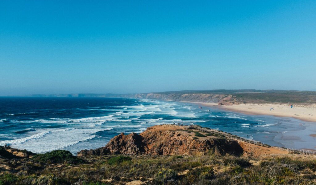 Landscape view of Praia da Bordeira in Algarve, showcasing waves crashing on Carrapateira surf