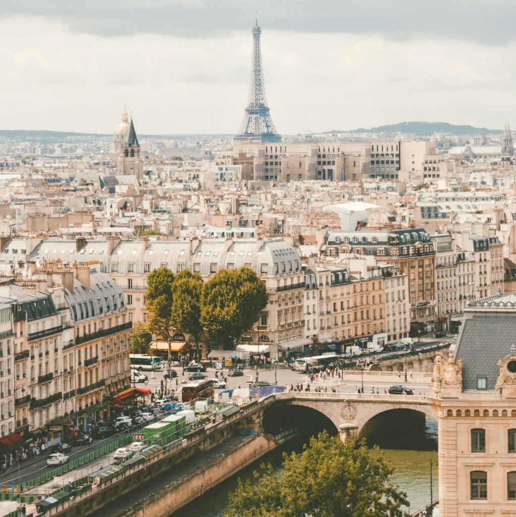 A scenic view of the city of Paris with the Eiffel Tower standing tall in the background, framed by charming streets and classic architecture