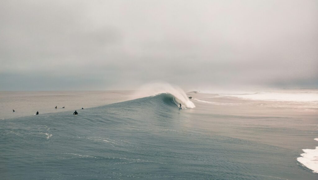 A surfer riding a massive barreling wave at Plage de la Gravière in Hossegor surf