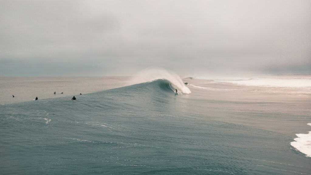A surfer riding a massive barreling wave at Plage de la Gravière in Hossegor surf