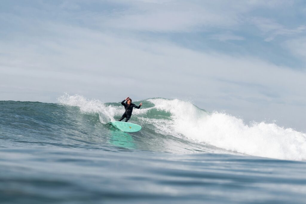 Surfer doing a cutback on a wave under blue skies at Sunset Cliffs Surf, CA, captured from the water