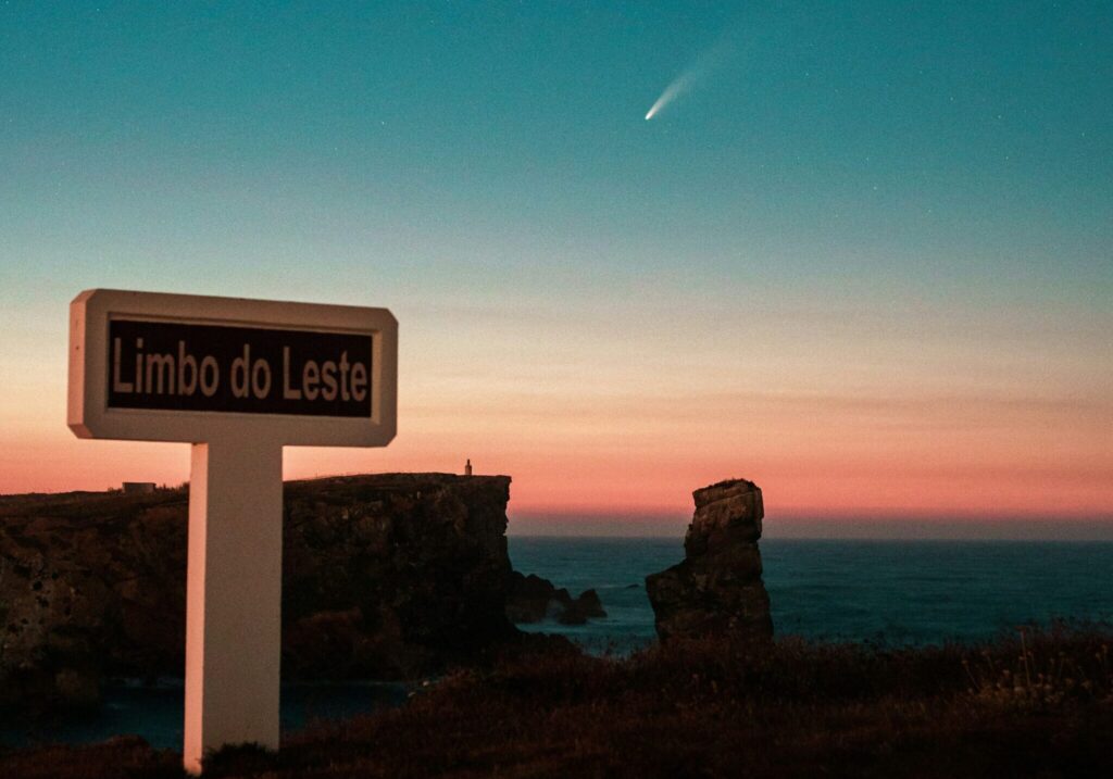 A meteor streaking across the sky against a backdrop of clear blue and pink hues in Peniche, Portugal