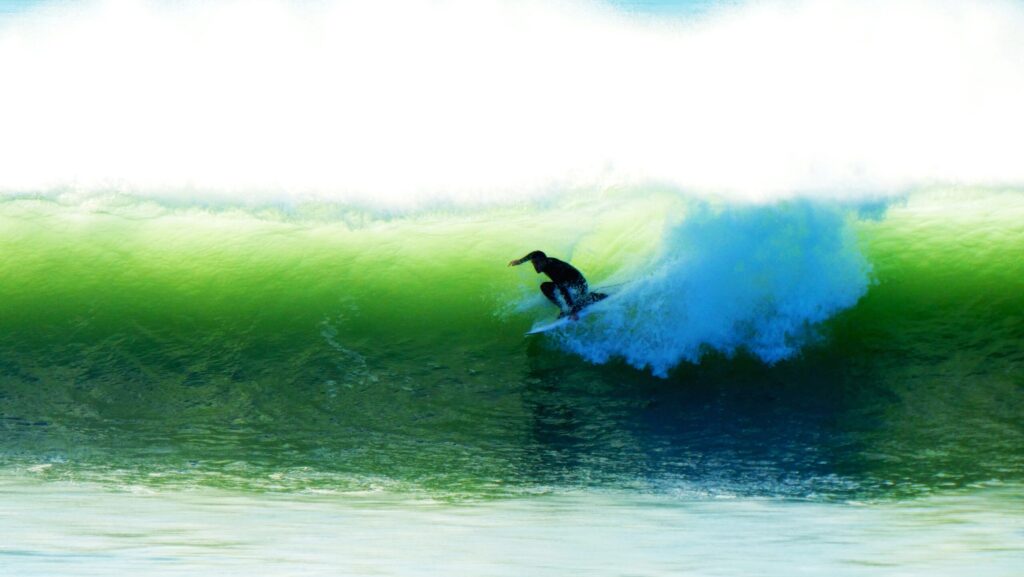A surfer pulls into the green colored barrel of a right-hand wave in Les Sables-d'Olonne Surf, France