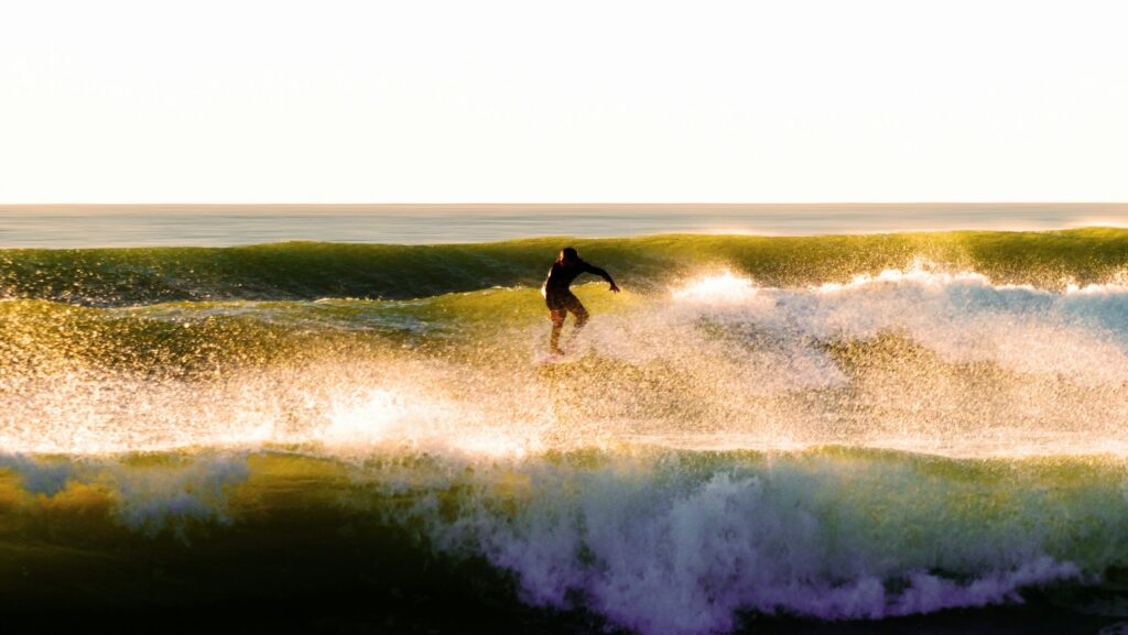 A surfer riding a left hand wave, looking down the line in Les Sables-d'Olonne, France