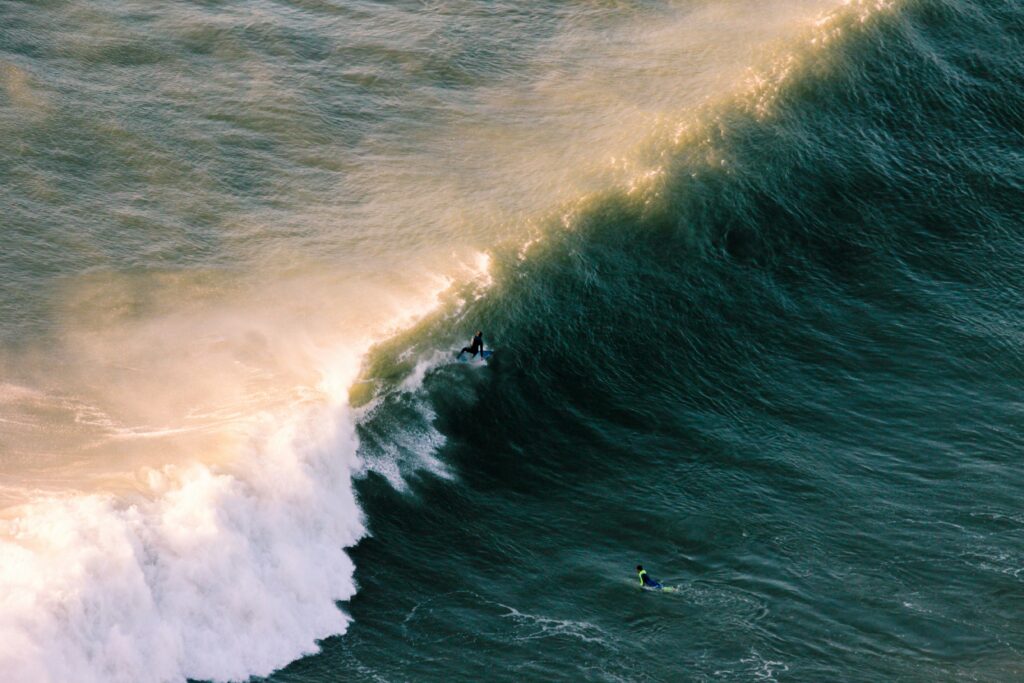 A large left-hand wave at Lobitos Surf Point, Lobitos, Peru, with a man surfing, captured from above, highlighting the vibrant ocean scene