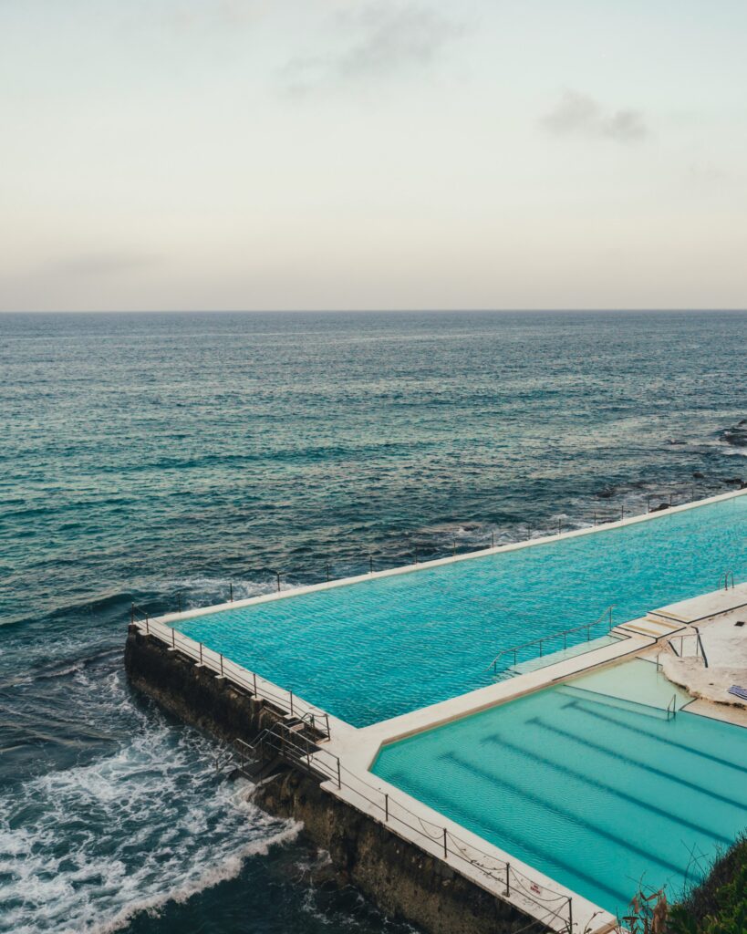 Bright blue water of Bondi Icebergs Pool, framed by the ocean in the background and clear skies