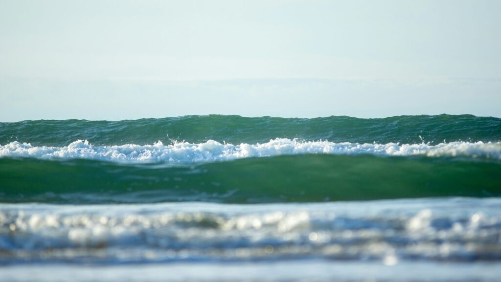 Rolling green-blue waves captured from a low angle in Lacanau surf, France
