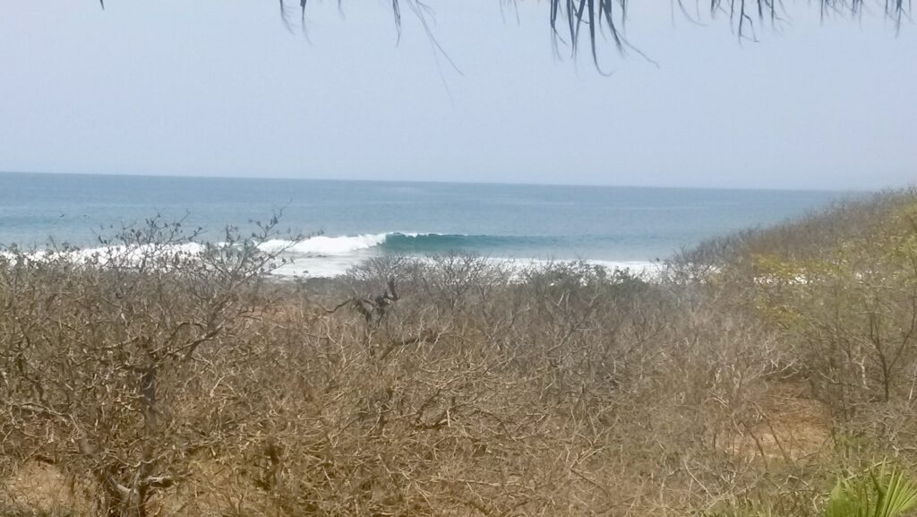Troncones Surf Point breaking as a left-hand point break, with clear skies and crisp water, empty of surfers