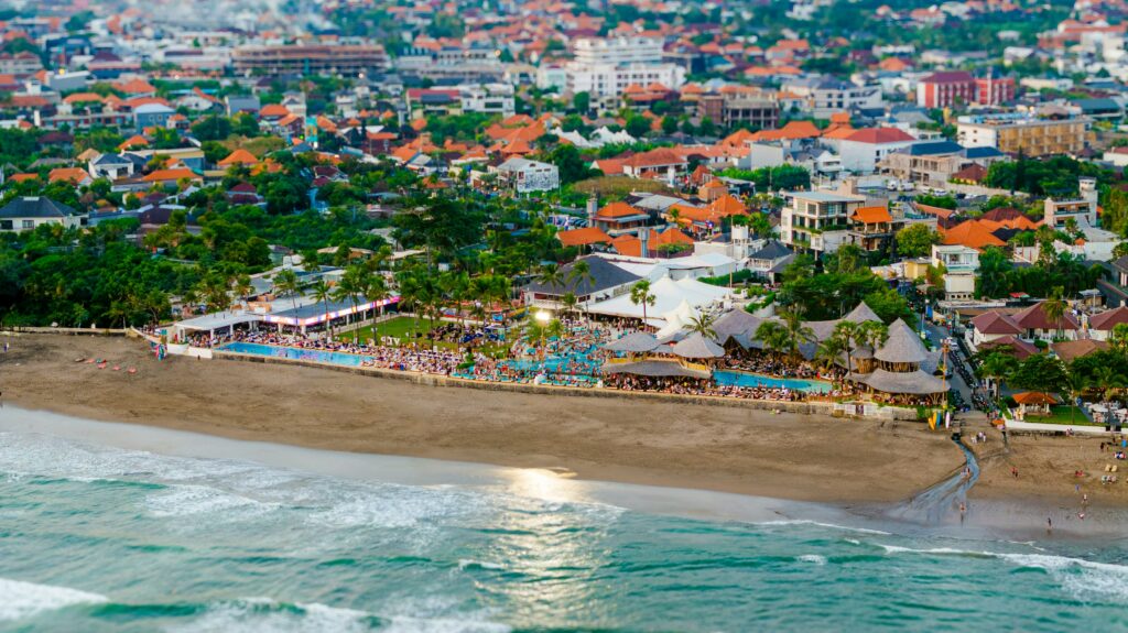 Drone view of Canggu Beach, Indonesia, showing Finns Beach Club with pools and crowds partying