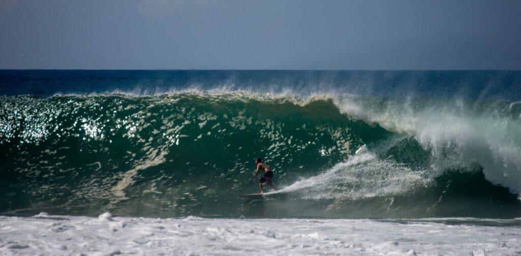 A surfer on a big right-hand wave at Playa Zicatela, Puerto Escondido surf, with the wave barrelling