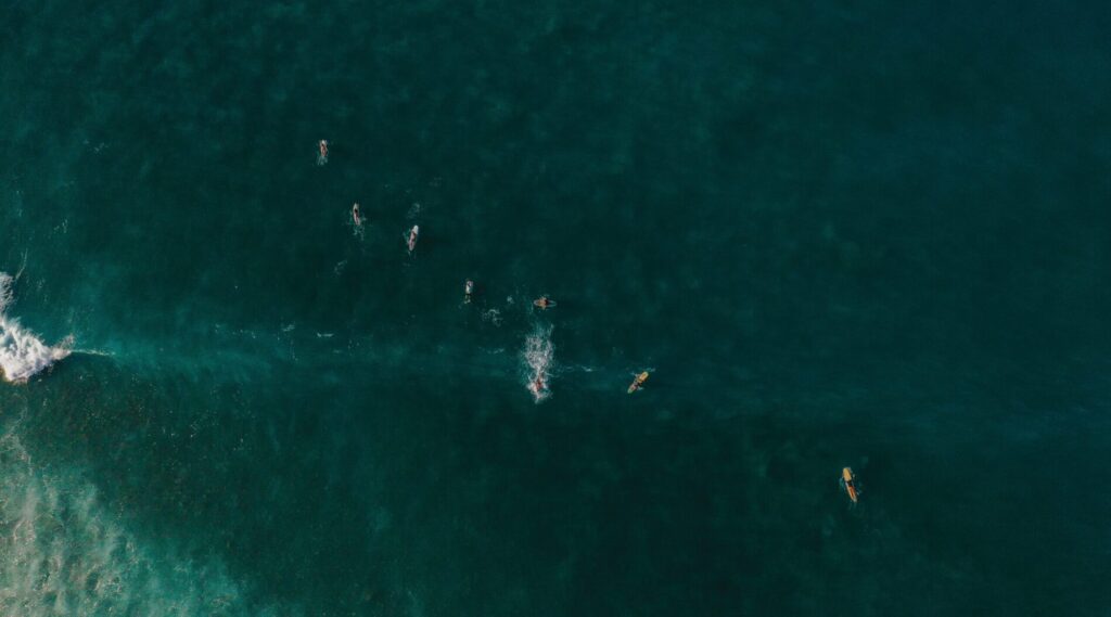 Bird's-eye drone view of Sayulita surf Mexico, with surfers in the ocean and deep blue water