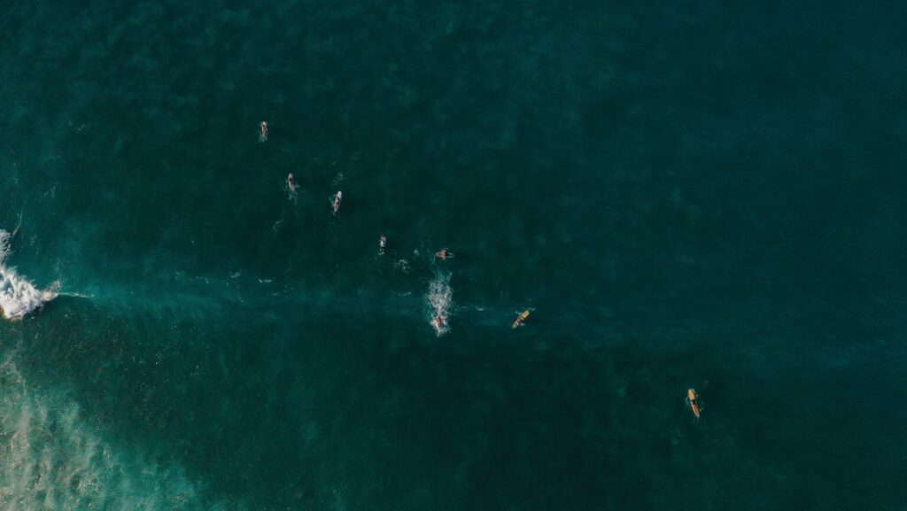 Bird's-eye drone view of Sayulita surf Mexico, with surfers in the ocean and deep blue water