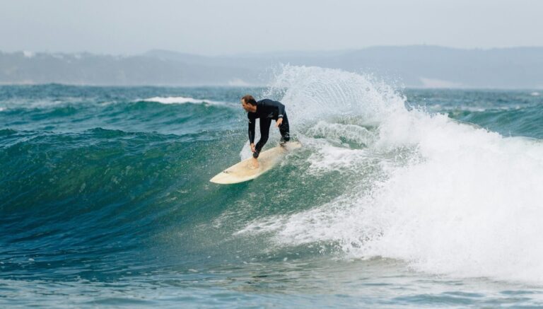 A surfer on a right-hand wave pulling a backside turn at Victoria Bay Surf, South Africa