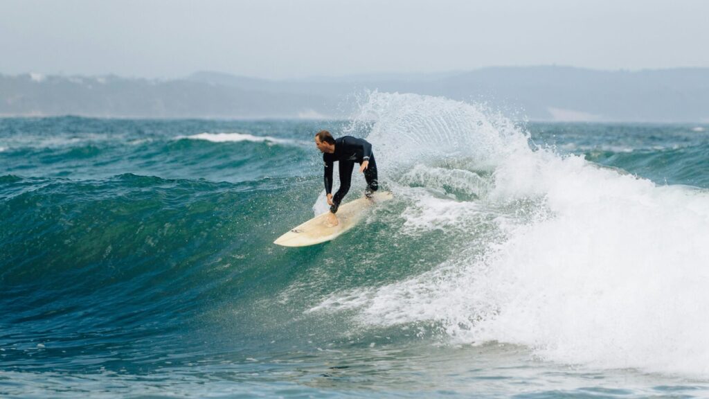 A surfer on a right-hand wave pulling a backside turn at Victoria Bay Surf, South Africa