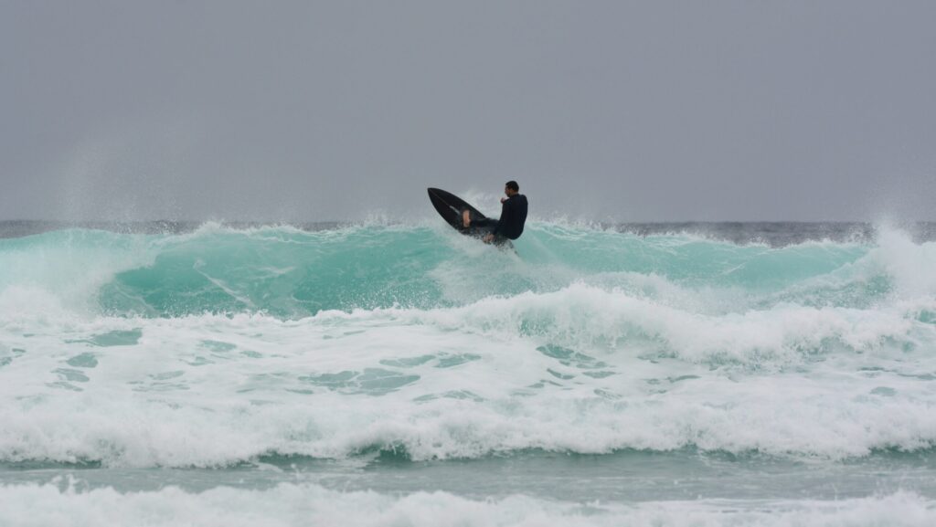 A surfer pulling off a turn on top of the wave at Watergate Bay, Newquay surf, United Kingdom Surf