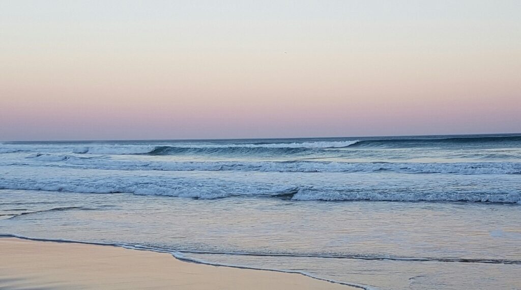 Waves at Wilderness Beach, South Africa, taken from the beach at dusk with wispy clouds and clear skies