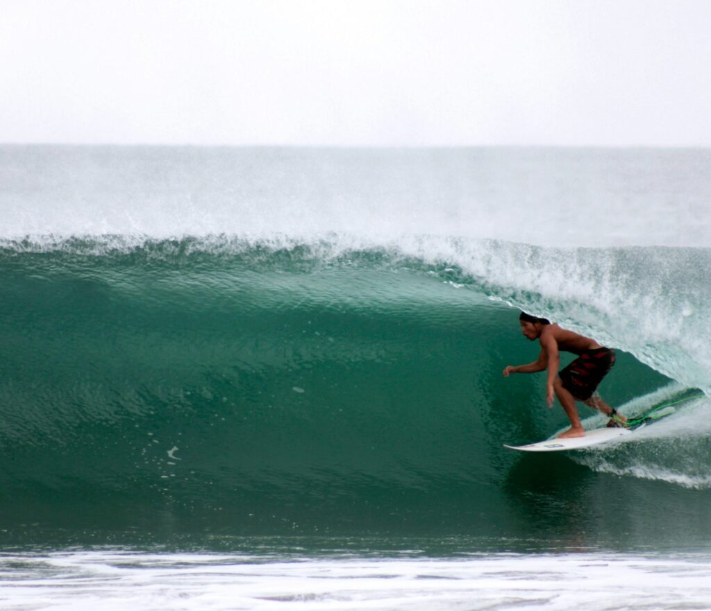 A surfer in a barrel on a right-hand wave in Barra de la Cruz surf, Mexico