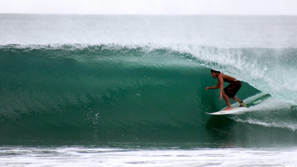 A surfer in a barrel on a right-hand wave in Barra de la Cruz surf, Mexico