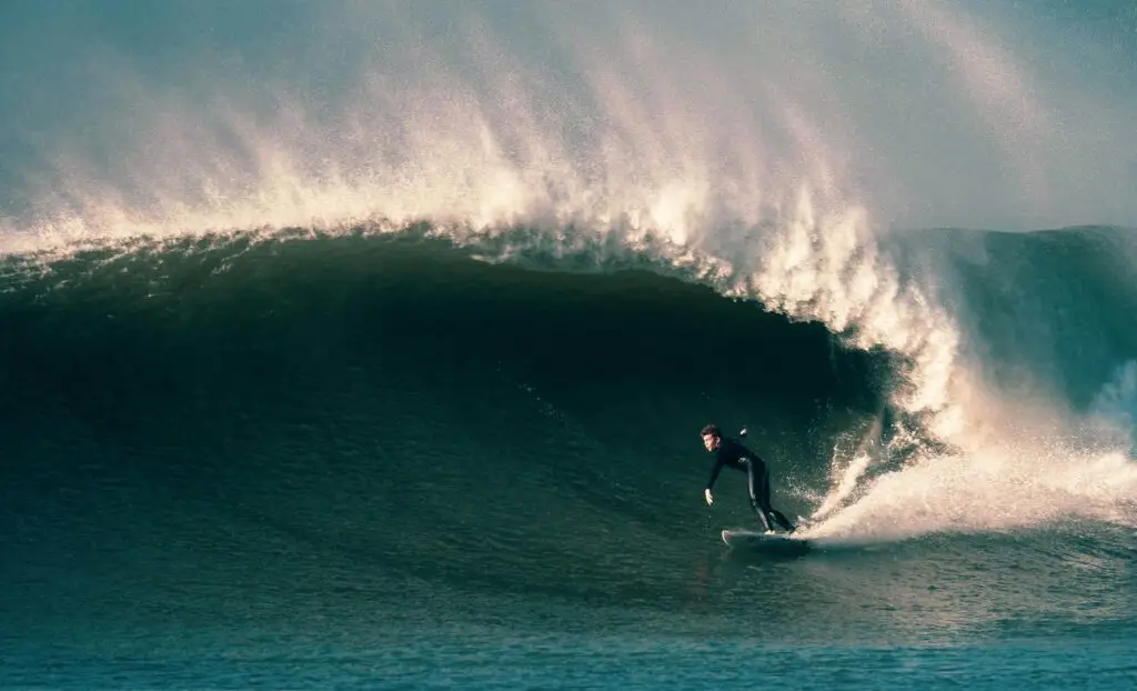 A surfer doing a bottom turn on a perfect right-hand wave with offshore winds at Croyde Bay surf, North Devon