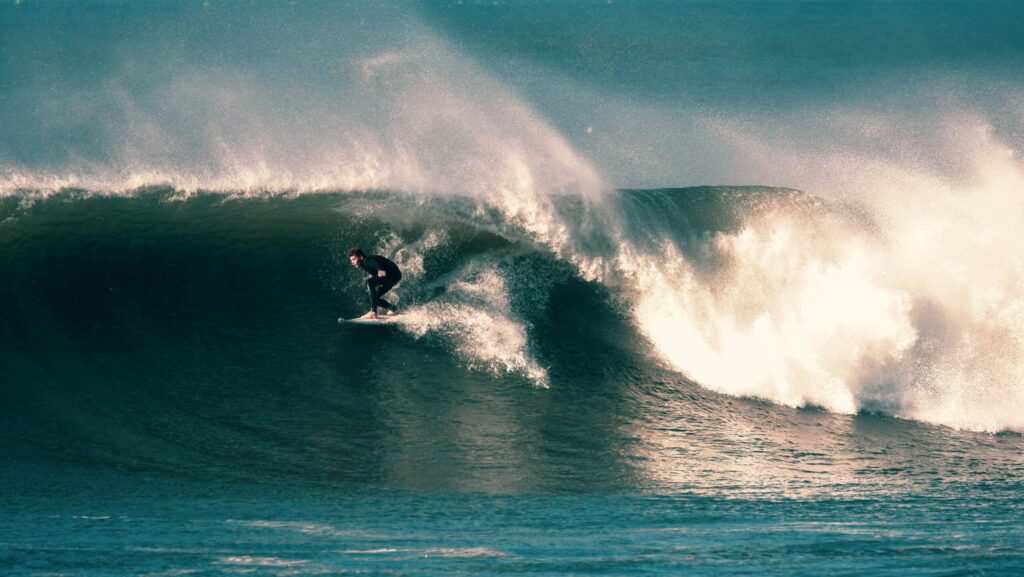 United Kingdom Surf Guide 2025 | Best Surf Towns With Easy Access A view of a large right-hand wave at Croyde Bay surf, North Devon, United Kingdom Surf