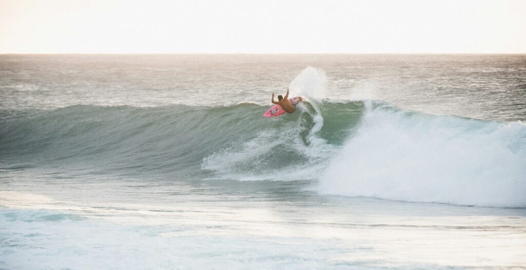 A surfer executing a huge top turn on a right-hand point break wave with lots of spray Barra de la Cruz surf