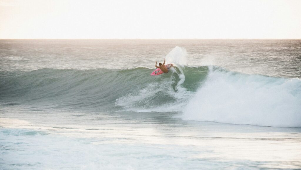 A surfer executing a huge top turn on a right-hand point break wave with lots of spray Barra de la Cruz surf