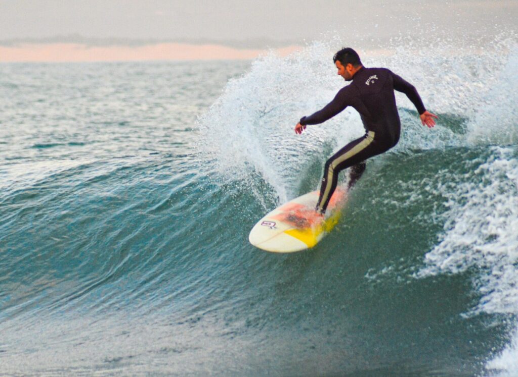 A surfer executing a cutback on a right-hand wave at Jeffreys Bay Surf, South Africa, with lots of spray