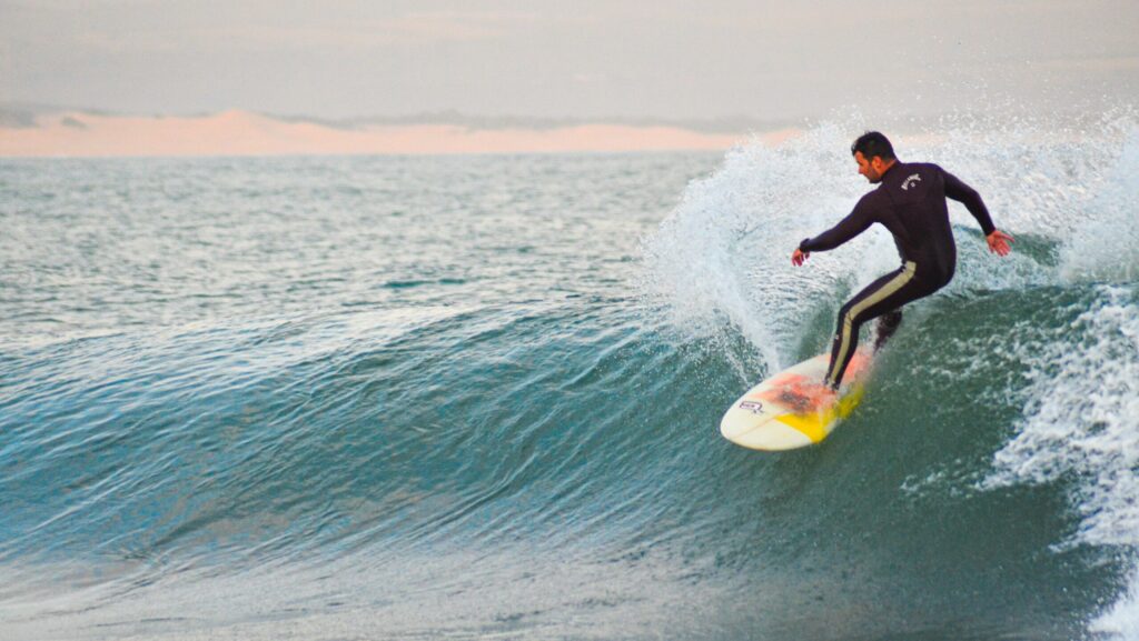 A surfer executing a cutback on a right-hand wave at Jeffreys Bay Surf, South Africa, with lots of spray