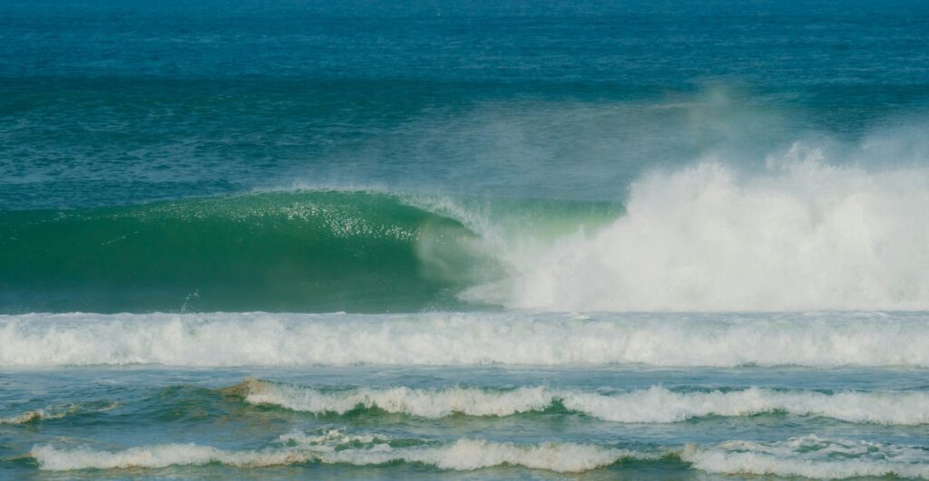 An empty barrelling wave at Barra de la Cruz, Mexico, with clear skies, taken from the beach