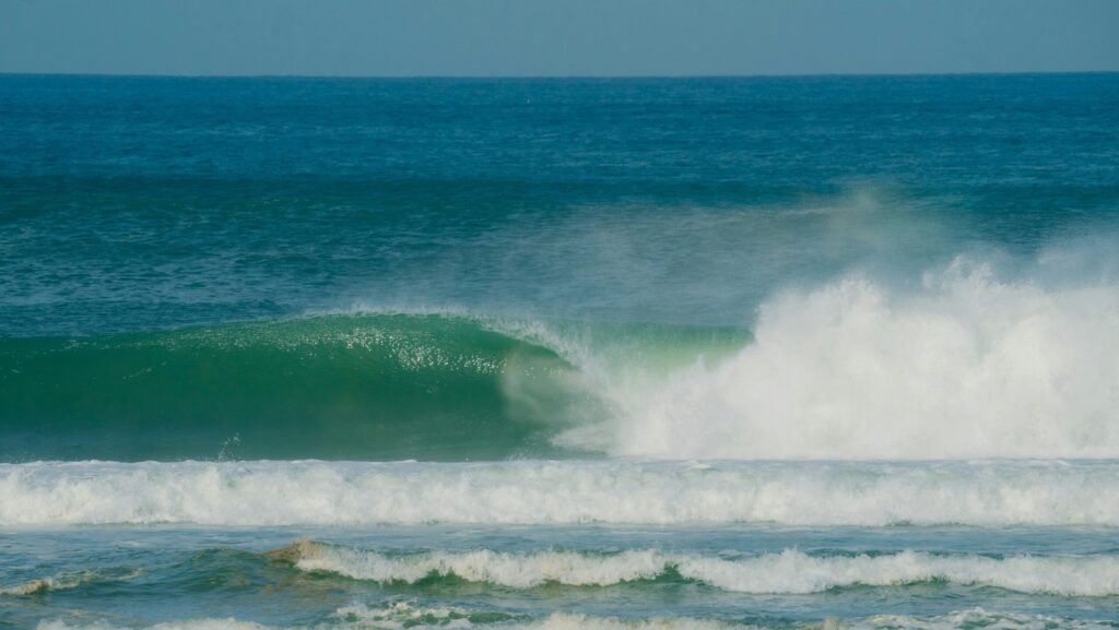 An empty barrelling wave at Barra de la Cruz, Mexico, with clear skies, taken from the beach
