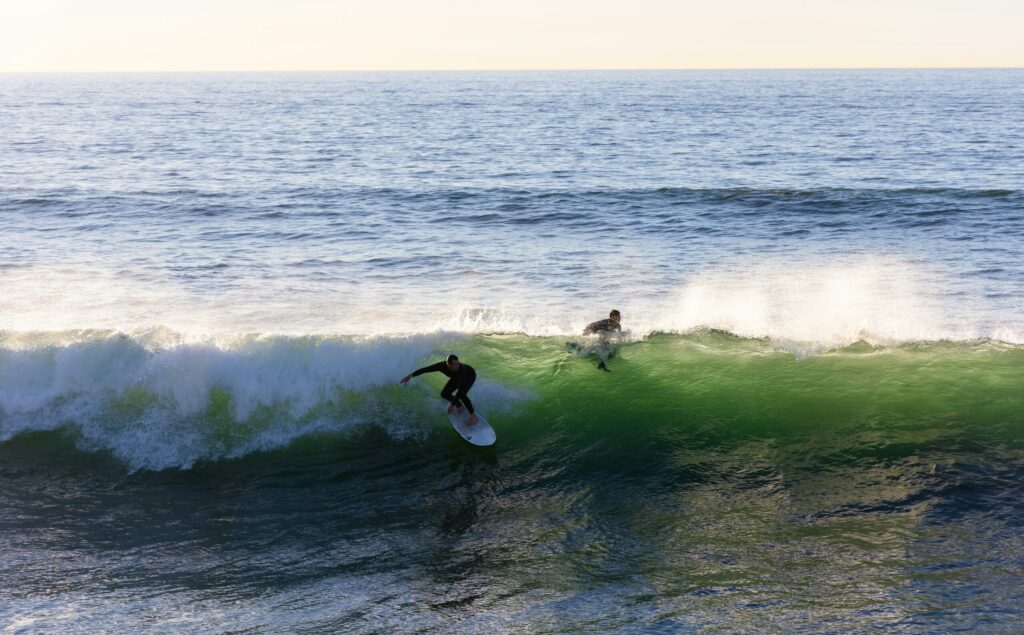 A surfer taking off on a left-hand wave with the surf reflecting on the water in Mundaka Surf, Spain