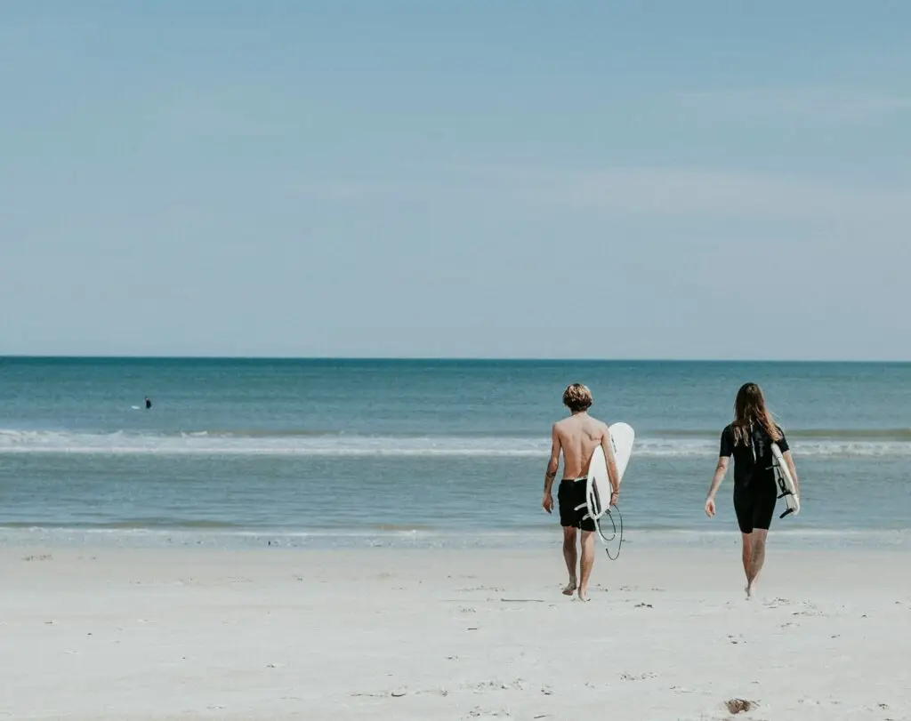 Two young surfers walk to the ocean on Seminyak Beach, eager to catch a wave in clean conditions