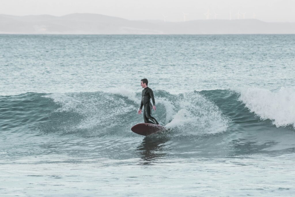 A surfer on a mal at Jeffreys Bay Surf, South Africa, riding a mellow wave and doing a bottom turn, looking down the line